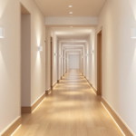 Langer schmaler Flur mit moderner Wand- und Bodenbeleuchtung in warmem Weiß, gestaltet in einem minimalistischen Stil mit hellen Wänden und Holzboden, flurbeleuchtung ideen für schmale ganggestaltung.