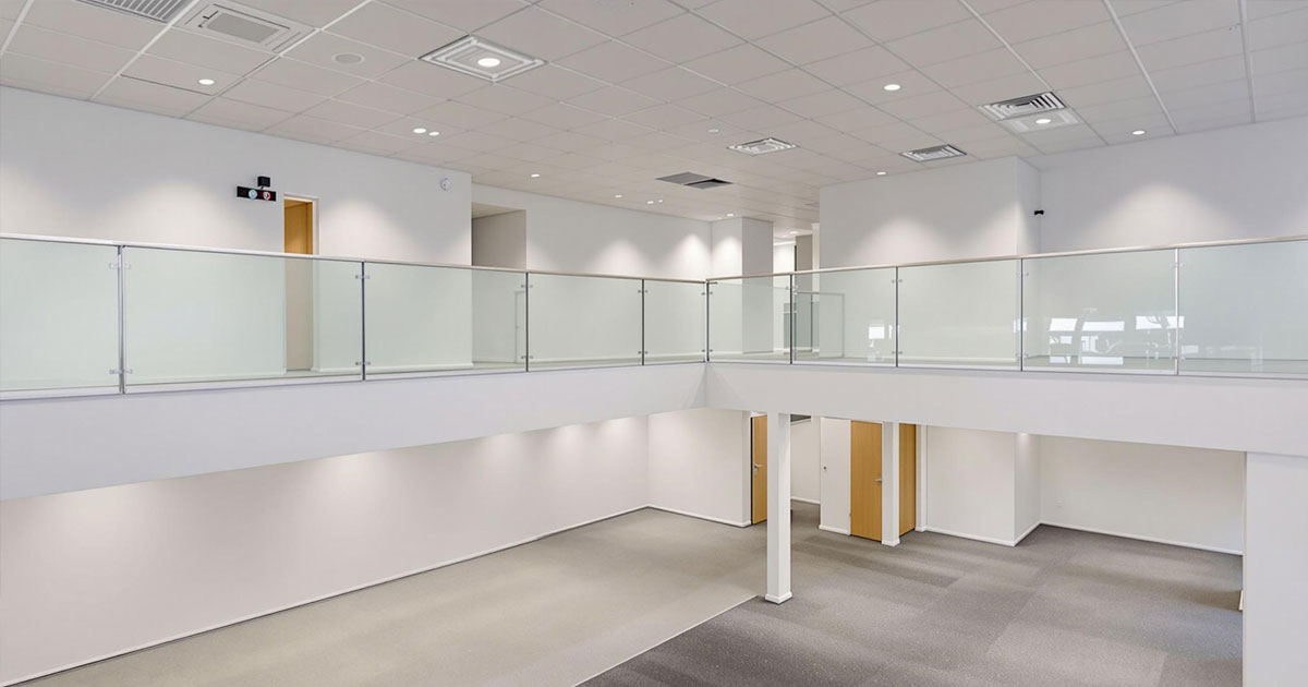 Gewerbe sanierung eines modernen zweistöckigen Bürogebäudes mit Glasgeländern und neutraler Farbgestaltung