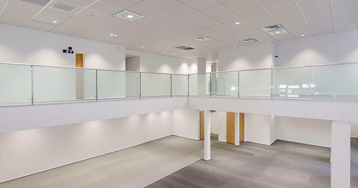 Projekt 369 zeigt eine modern zweigeschossige Büroetage mit Glasgeländer und weißen Wänden.